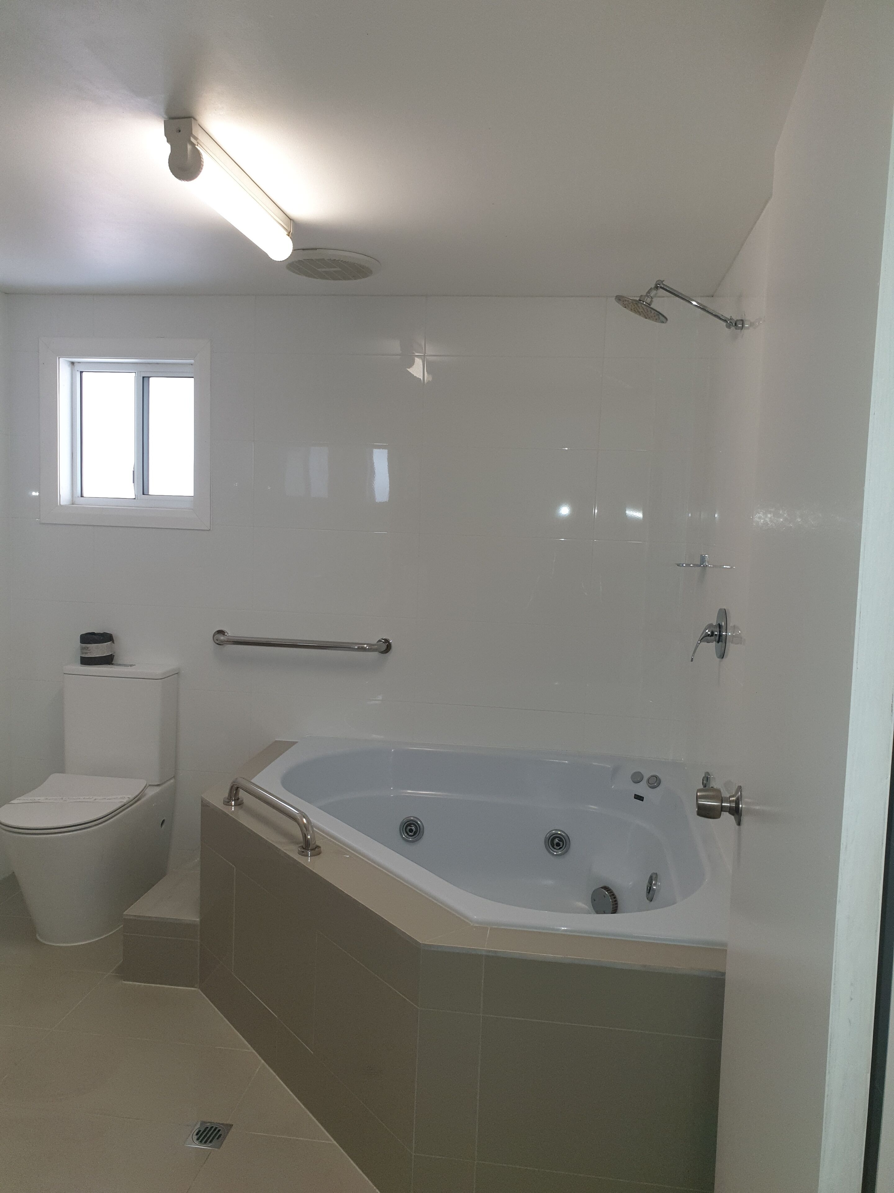 Un baño con bañera, inodoro y ventana.