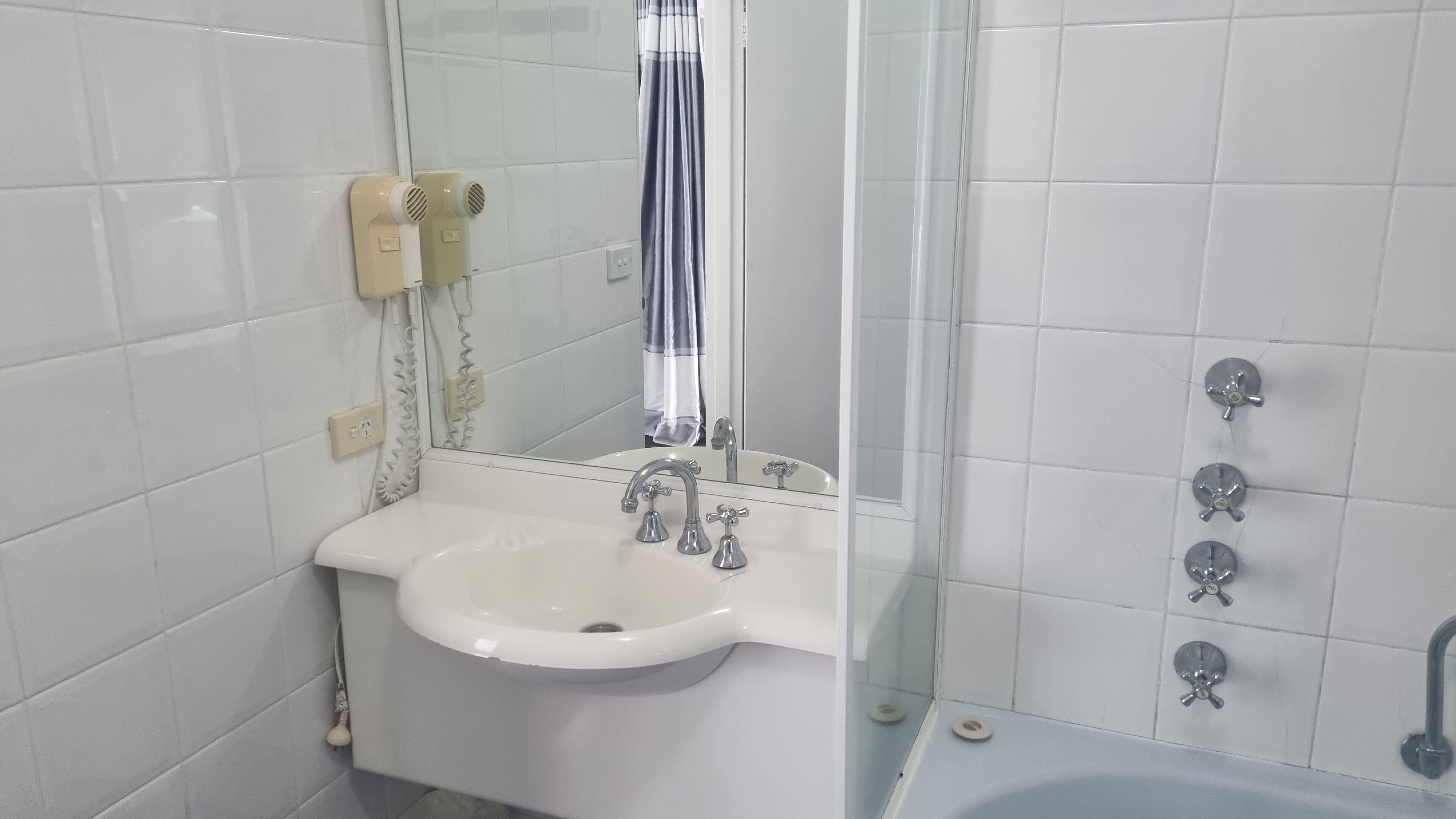 A bathroom with a white sink, a mirror, a shower with a glass door, and a bathtub.