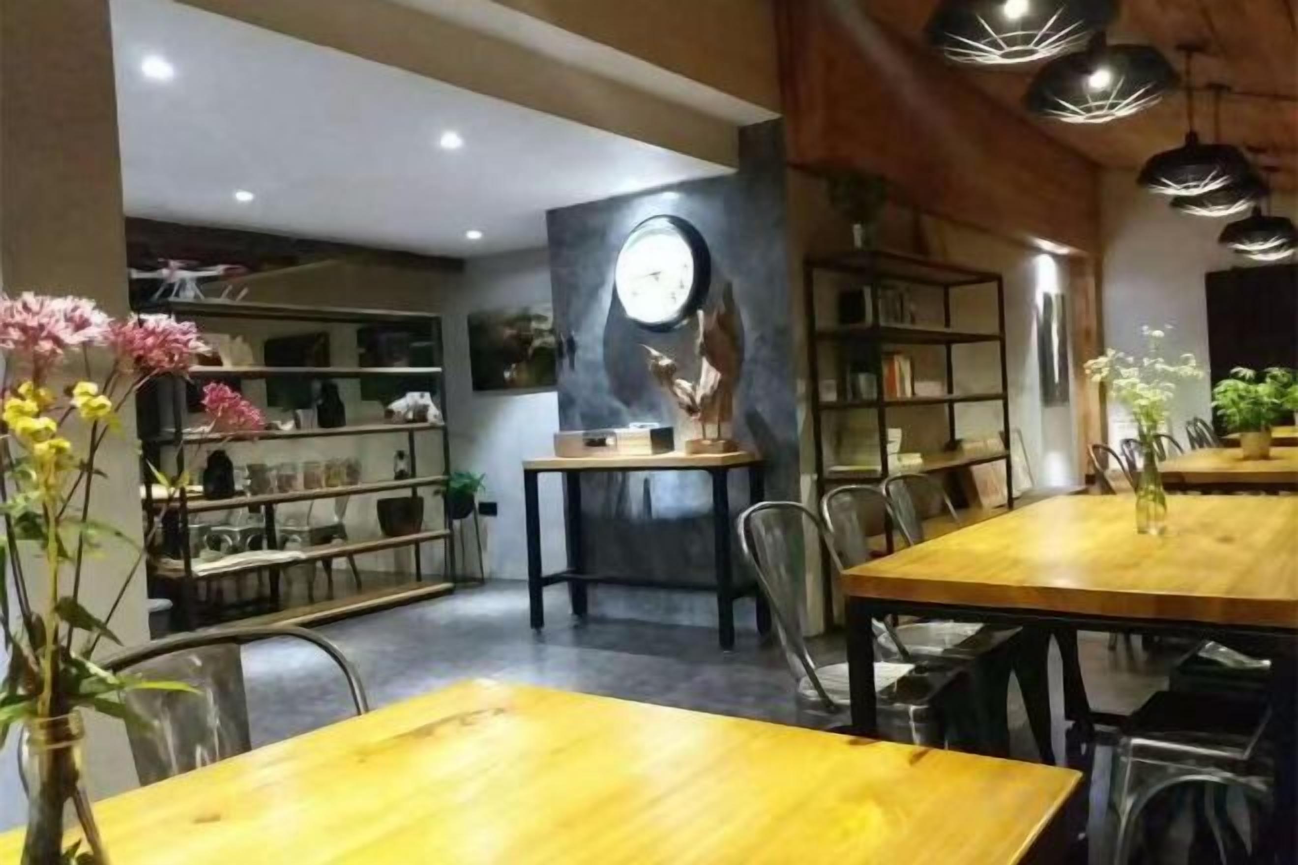 Un comedor con una mesa y sillas de madera, rodeado de estanterías con libros y objetos decorativos.
