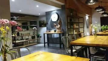 Un comedor con una mesa y sillas de madera, rodeado de estanterías con libros y objetos decorativos.
