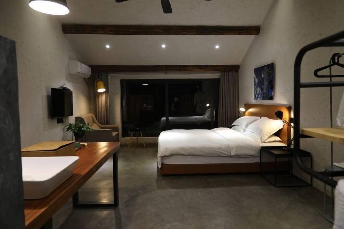 Une chambre à coucher avec un lit, une table de chevet et un luminaire suspendu.