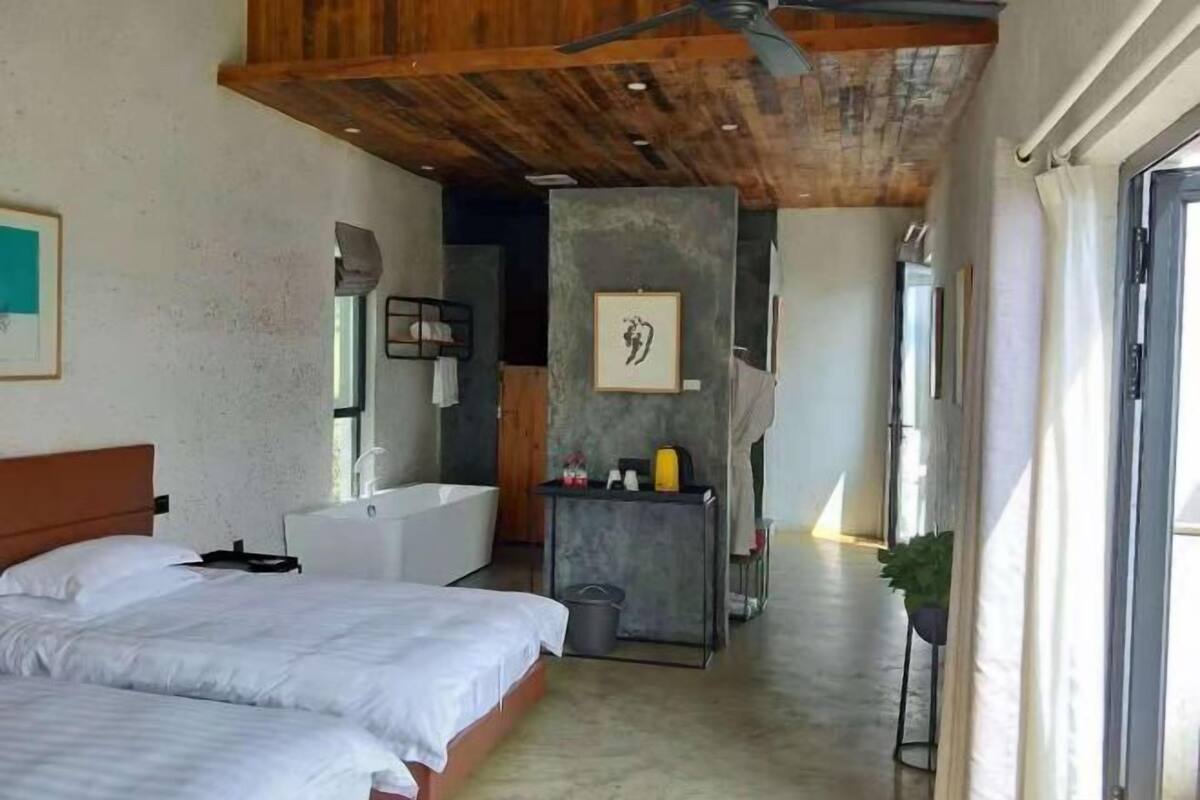 Une chambre avec deux lits, une baignoire et une petite table avec des articles de toilette.