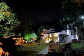 A modern hotel with a well-lit entrance, a visible outdoor seating area, and a staircase leading to the main building. - Yueguo Shanqiu Hostel (Hangzhou)