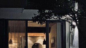 Vista interior de una habitación con techo de madera, un espejo redondo y una lámpara colgante.