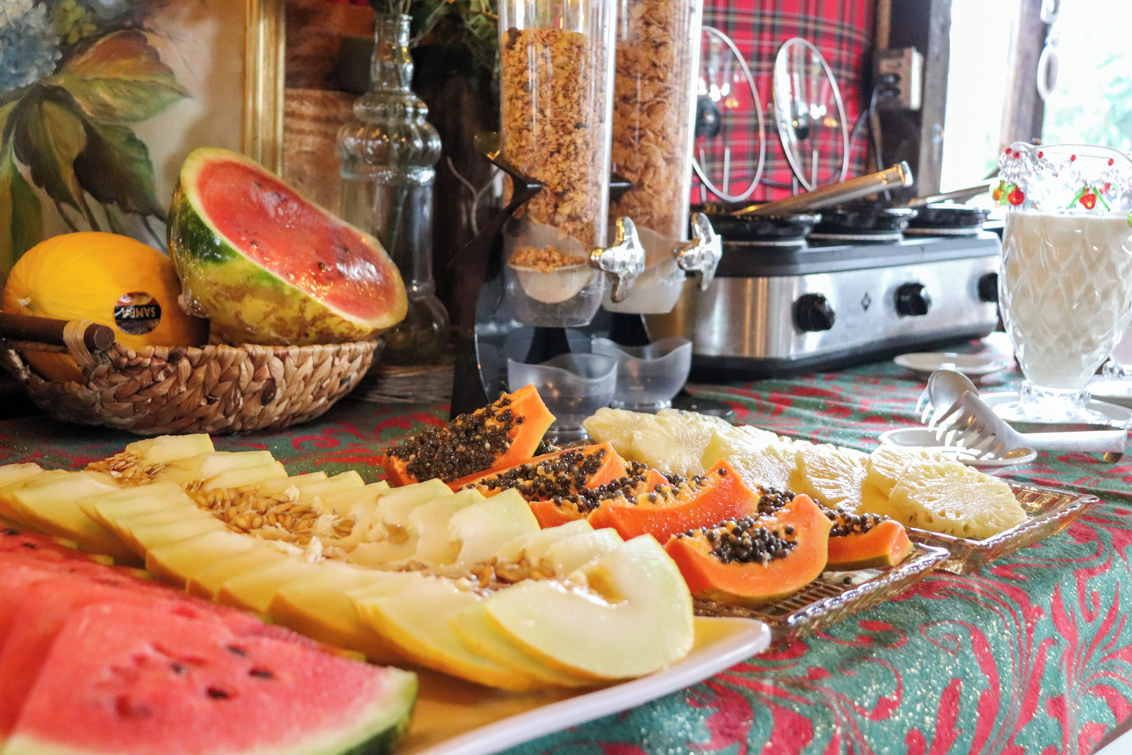 A table with various fruits and a bottle of wine.