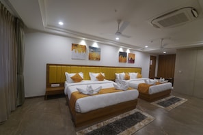 A hotel room with two beds, a wooden headboard, a ceiling fan, and artwork on the wall.