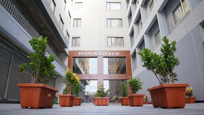 Hotel Stature Inn har en modern fasad, pryds av krukväxter framför entrén och erbjuder fri sikt mot ingången.