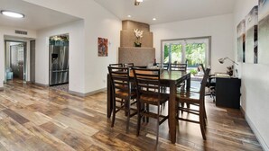 Un'ampia cucina con zona pranzo, pavimento in legno, ventilatore a soffitto e un'ampia finestra.