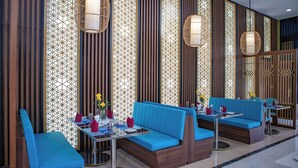 A modern interior with blue seating, decorative panels, and hanging light fixtures. - Tea Resort Prenn (Xuan Huong - Da Lat)