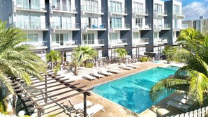 Ett modernt hotell med pool, flera balkonger och solstolar.