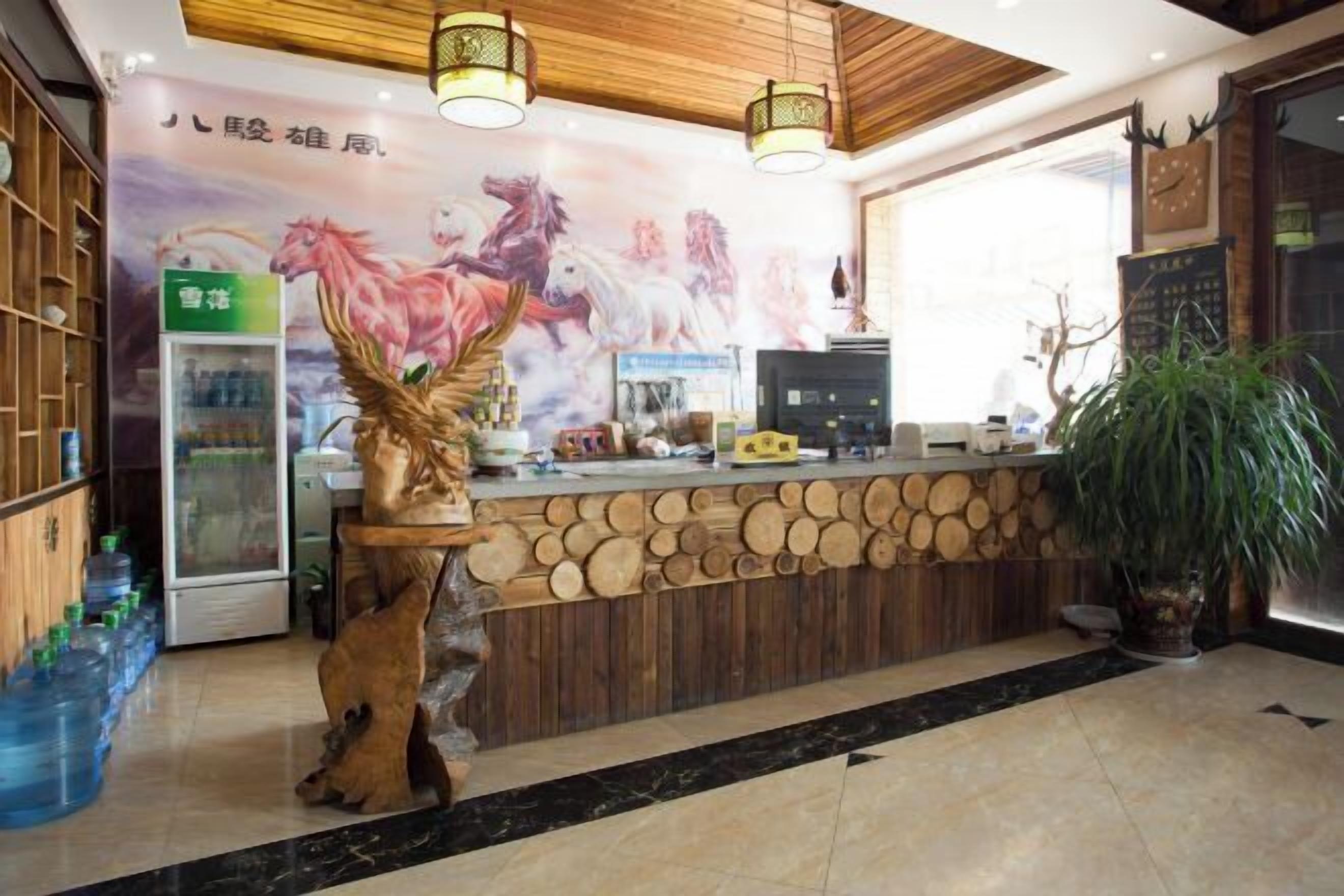 A reception area with a wooden counter, a decorative horse sculpture, a refrigerator, and a large window.