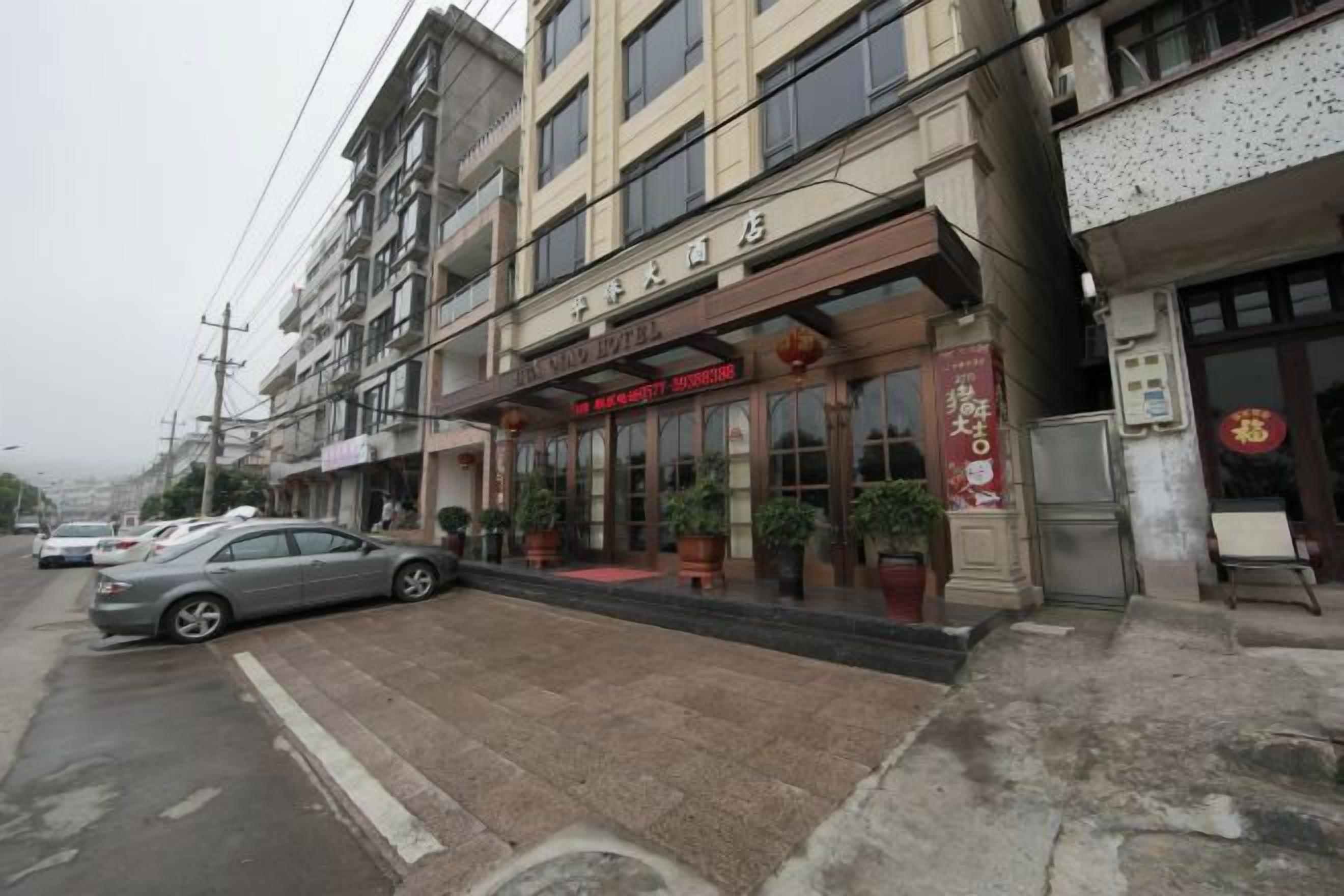 A hotel with a red awning, a signboard, and a red Chinese character sign.