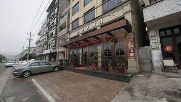 A hotel with a red awning, a signboard, and a red Chinese character sign.
