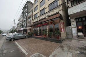 A hotel with a red awning, a signboard, and a red Chinese character sign. - Wenzhou Dongtou Overseas Chinese Hotel (Wenzhou)