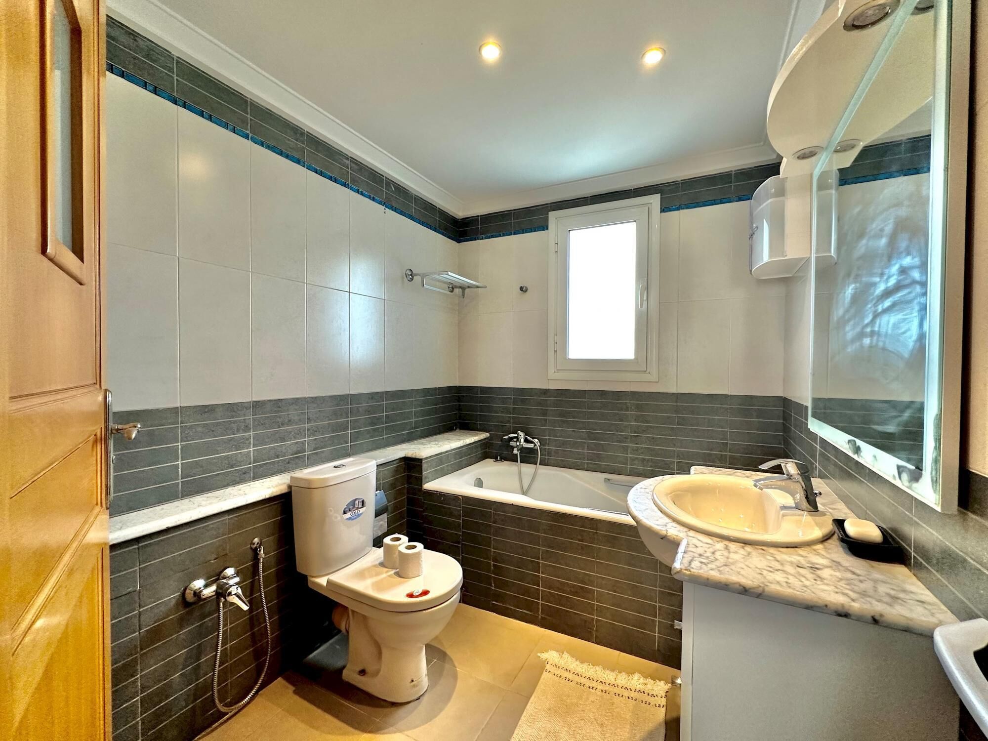 Un bagno moderno con WC, lavandino e vasca da bagno.
