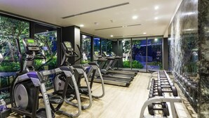 Un gimnasio moderno con cintas de correr, elípticas y bancos de pesas.