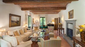 Amplia sala de estar con chimenea, asientos cómodos y vistas al exterior.