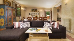 Ein gemütliches Wohnzimmer mit einem dunkelgrauen Sofa, einem kleinen Couchtisch und einer Kommode mit Dekorationsgegenständen.