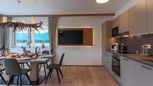 A modern kitchen with wooden cabinets, a built-in oven, and a microwave. - Accommodation with sauna near the ski lift (Mittersill)