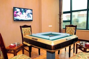 A pool table with chairs around it, a television mounted on the wall, and a window with a view. - Shenhang Yinju Mingzhu Hotel (Jiashan)