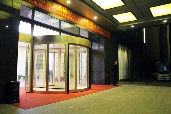 A hotel entrance with a revolving door, a red carpet, and a sign above the door. - Shenhang Yinju Mingzhu Hotel (Jiashan)