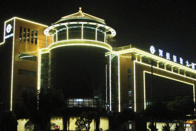 Een hotel met een opvallende, ronde constructie en een bord met Chinese karakters.