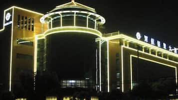 A hotel with a prominent circular structure and a sign with Chinese characters.