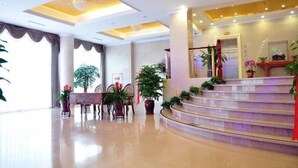 A spacious lobby with a polished floor, a grand staircase, and several potted plants. - Shenhang Yinju Mingzhu Hotel (Jiashan)
