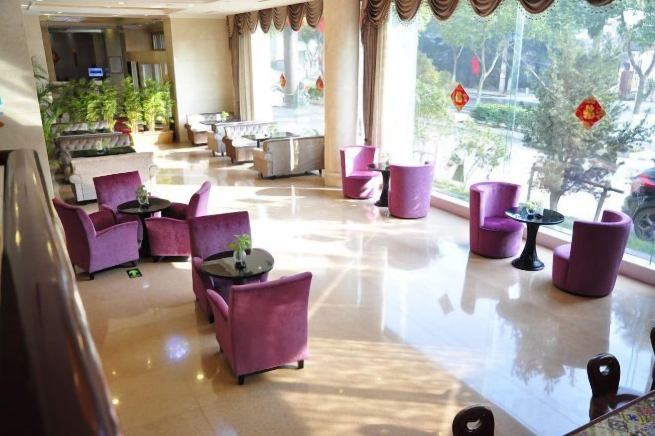A hotel lobby with purple seating, a reception desk, and large windows.
