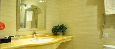 A bathroom with a sink, mirror, towel rack, and a plant.