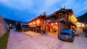 A traditional wooden building with a car parked in front. - Zhongting Xiyun Hotel (Songpan)
