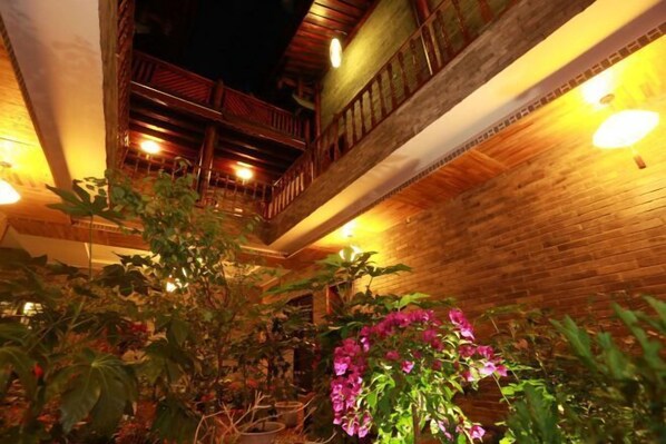 Un espacio interior con paredes de madera, un balcón y plantas en macetas.
