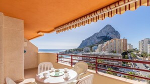 A balcony with a table set for two, overlooking a beach and a mountain. - Zafiro 26B - Grupo Turis - Calpe, Costa Blanca (Calpe)