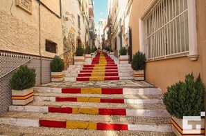 Steps lead up to the entrance of a charming building with traditional architecture and lush greenery.