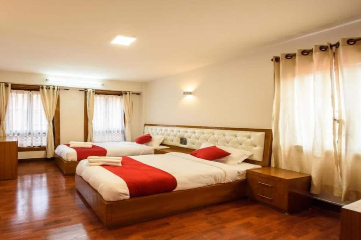 Een hotelkamer met twee bedden, houten vloeren en een modern design.