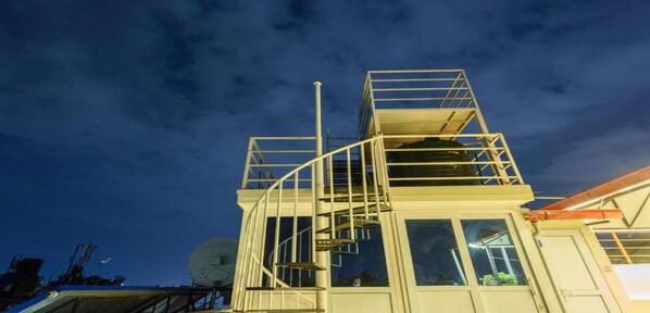 Eine mehrstöckige Struktur mit Wendeltreppe und Satellitenschüssel.