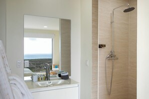 Ein modernes Badezimmer mit großem Spiegel, Waschbecken und Dusche.