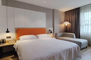 A hotel room with a large bed, a bedside table with a lamp, a chair, and a view of the outdoors through sheer curtains. - Qianyi Yicheng Hotel (Yulin Shizi Street Yuntian Palace) (Yulin)