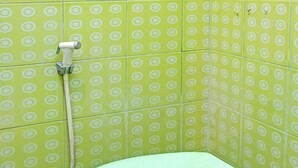 A toilet with a green lid in a bathroom with green patterned tiles. - OYO 92359 Kost Maluku 36 Family Residence (Kanigoro)