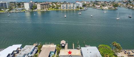 An aerial view of a marina with boats, buildings, and a prominent red star on a building.