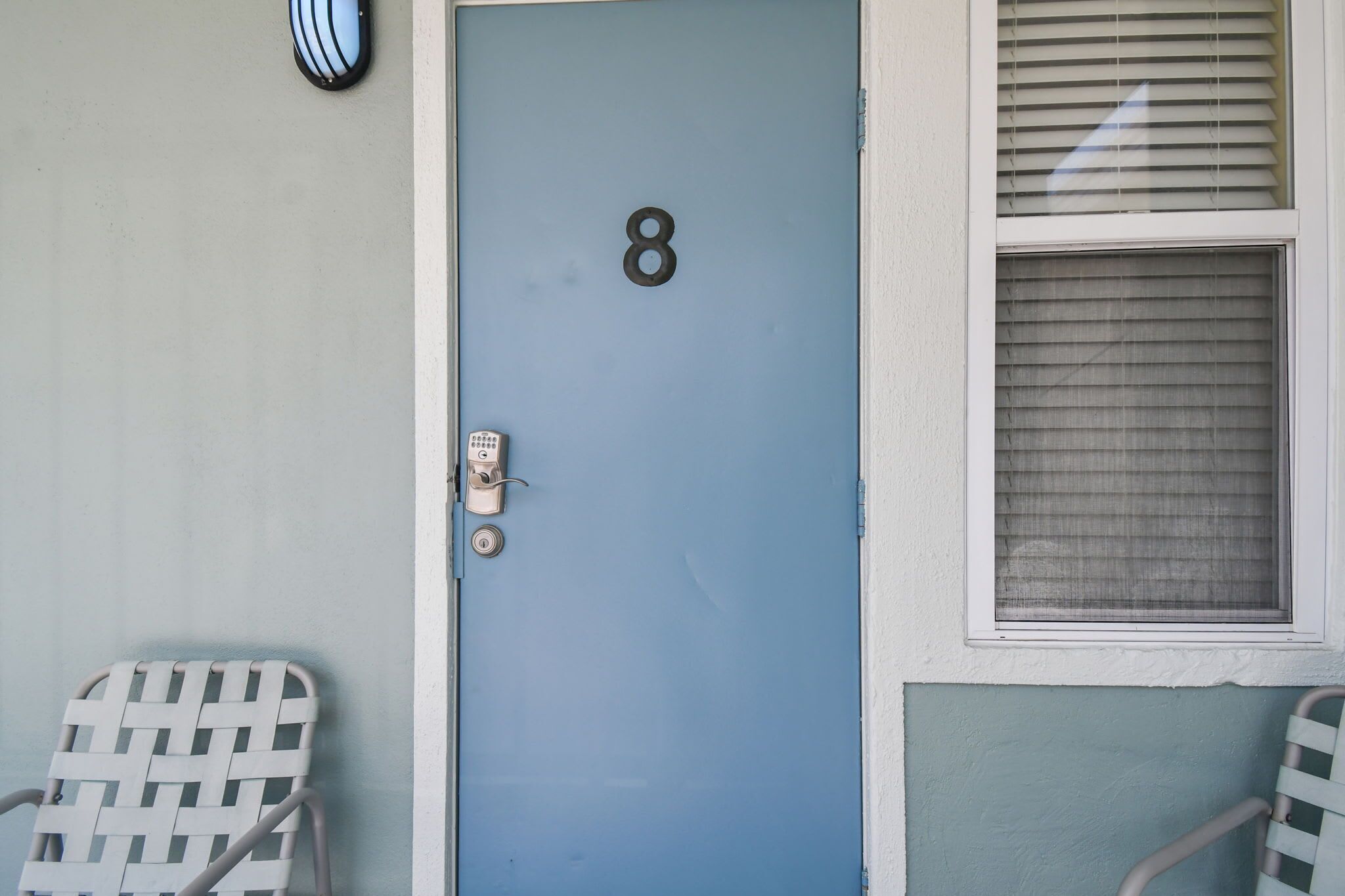 A blue door with the number 8, a keyhole, and a doorbell.