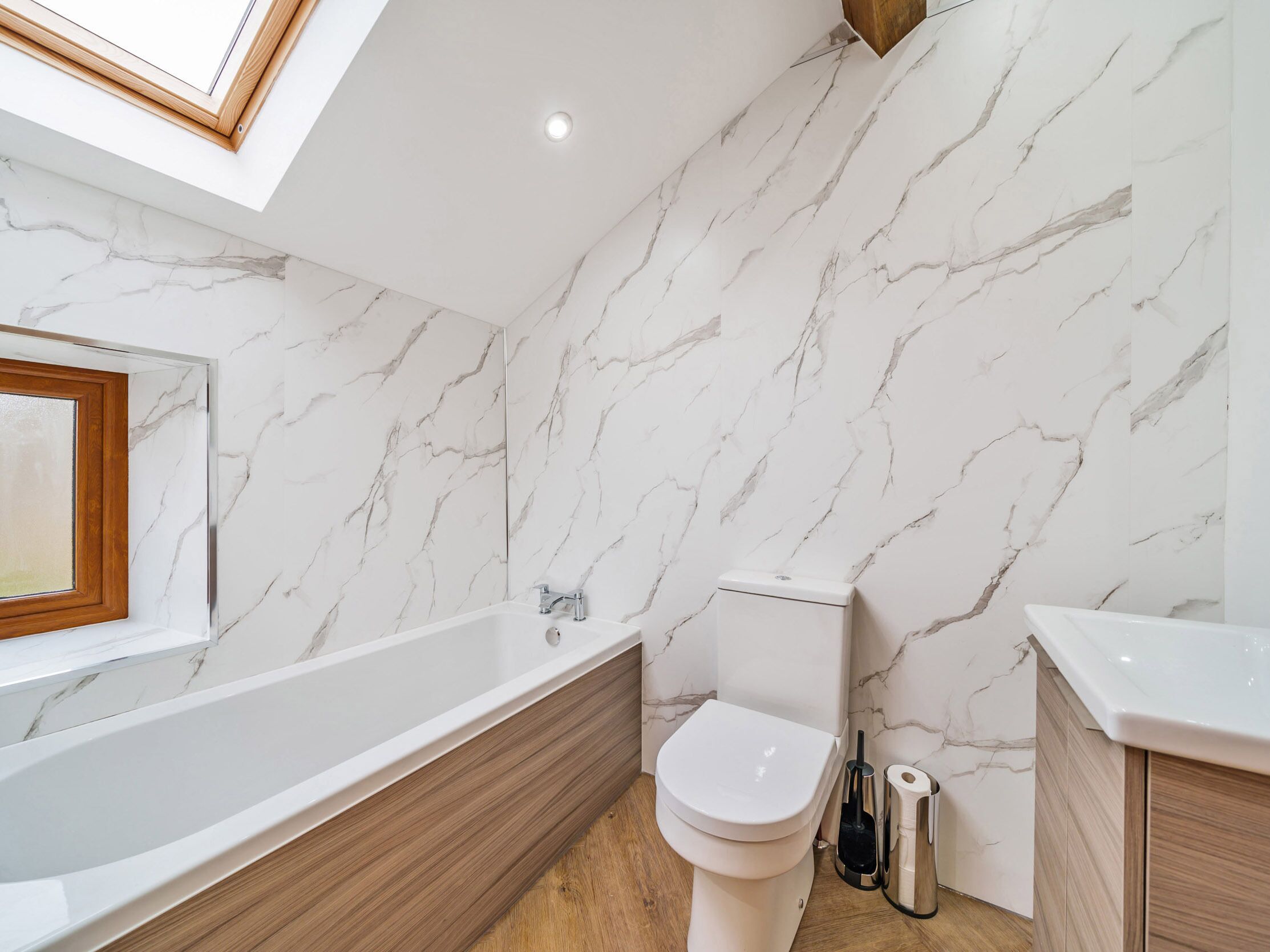 A modern bathroom with a freestanding bathtub, a toilet, and a sink.