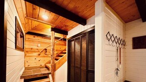 A wooden staircase leading to a loft area with a bench and a wall-mounted rack. - Lakefront with private dock & fire pit - Bunk House Cabin (Island Park)