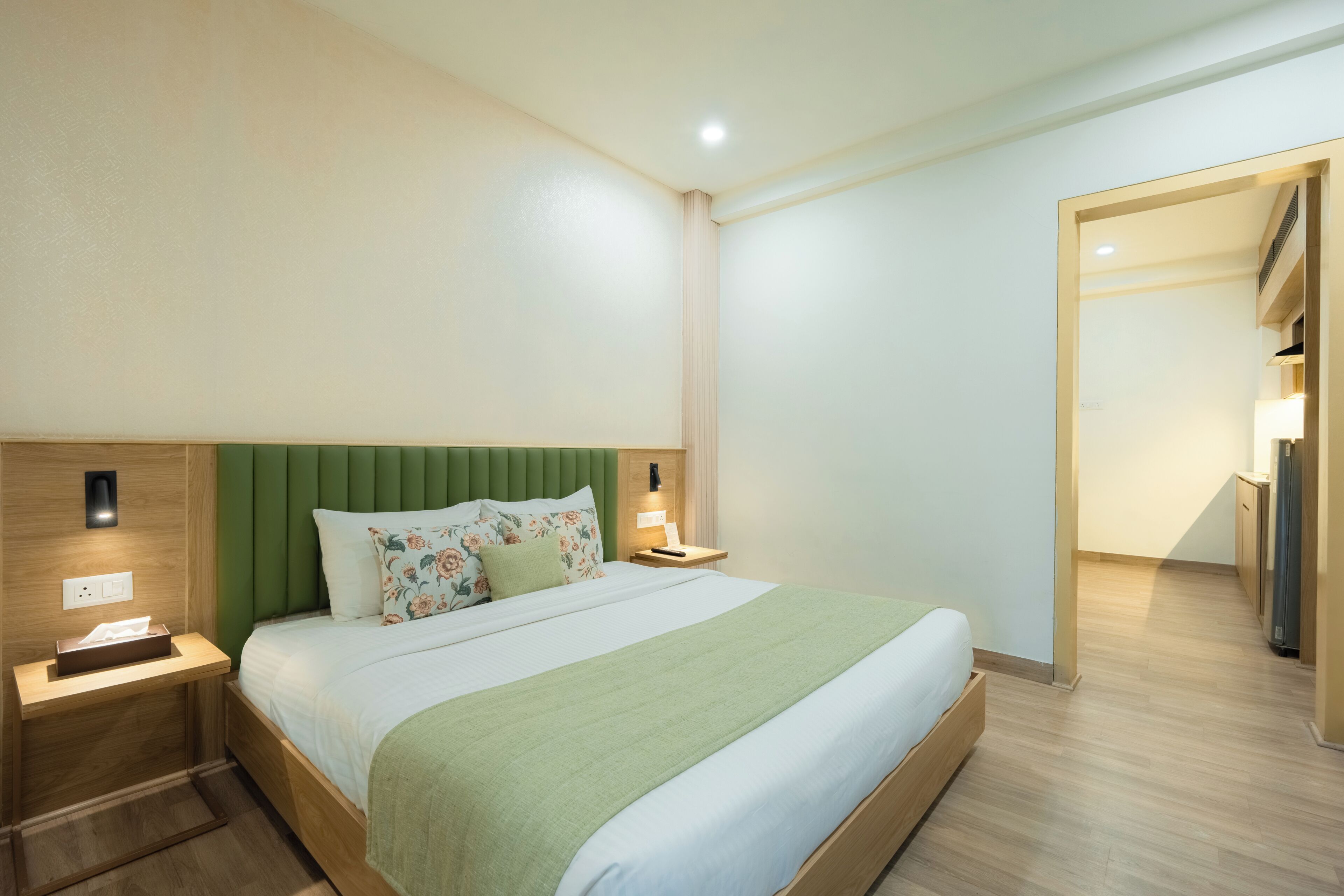 Una habitación de hotel con cama, mesitas de noche, lámpara y armario.