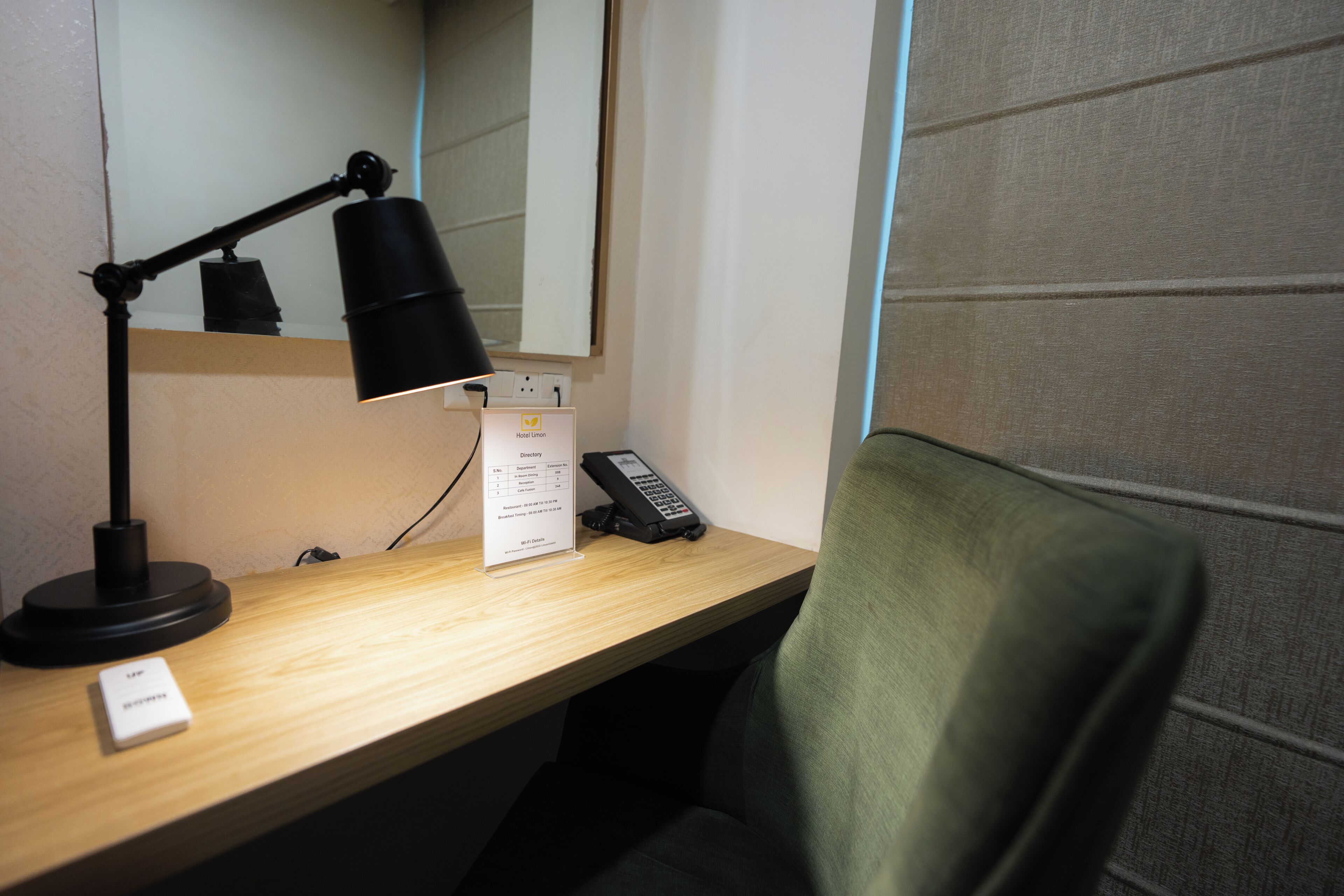 A desk with a lamp, a telephone, and a sign.