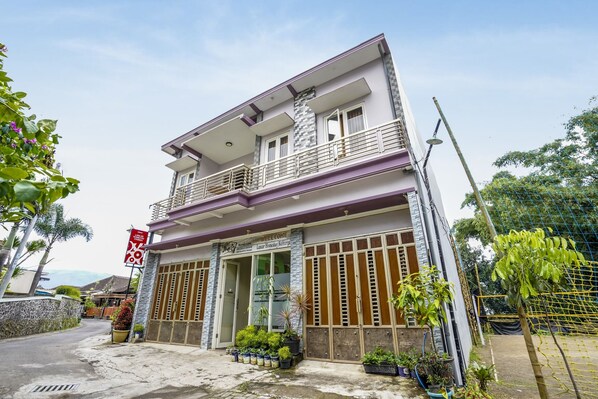A two-story building with a balcony, a signboard, and potted plants. - Hotel O Lancar Homestay Syariah (Batu)