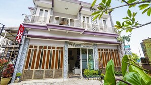 A two-story building with a balcony, a signboard, and potted plants in front. - Hotel O Lancar Homestay Syariah (Batu)