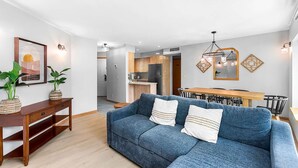 Ein modernes Wohnzimmer mit einer Couch, einem Holzkonsole und einem Essbereich mit Tisch und Stühlen.
