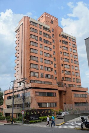 A tall brick building with multiple floors and numerous windows.