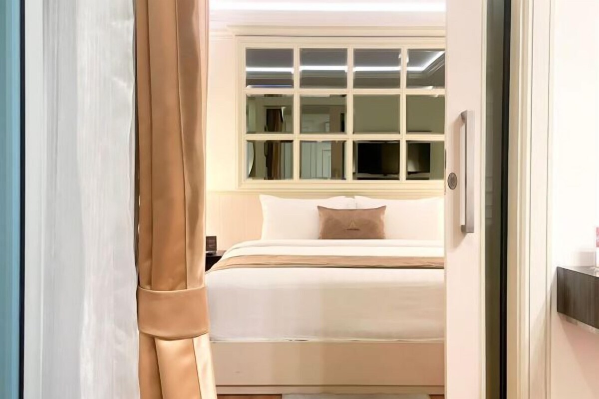 Une chambre d’hôtel avec un lit, une fenêtre et une porte.